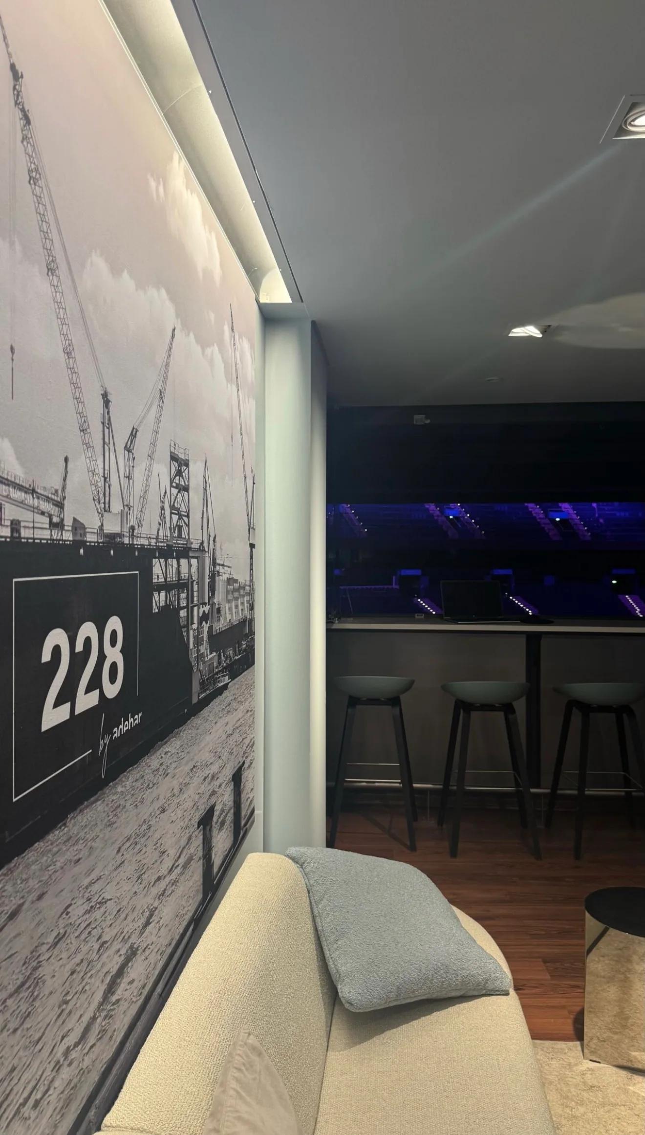 Die renovierte Loge 228 mit Sofa, Hafenmotiv und Blick in die Arena